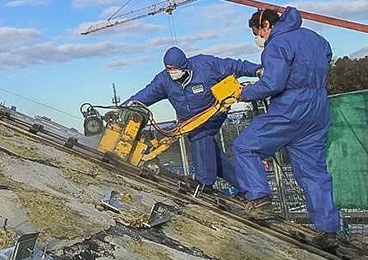 Zwei Mitarbeiter von Luckei Betonfrästechnik führen eine Schadstoffsanierung durch.