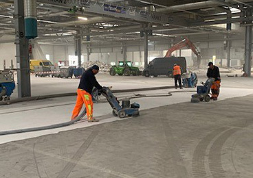 Mehrere Mitarbeiter von Luckei Betonfrästechnik führen eine Oberflächenbearbeitung durch